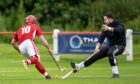 Kingussie keeper Rory McGregor (right) makes a stop from Keith MacRae (Kinlochshiel). Image: Neil Paterson.