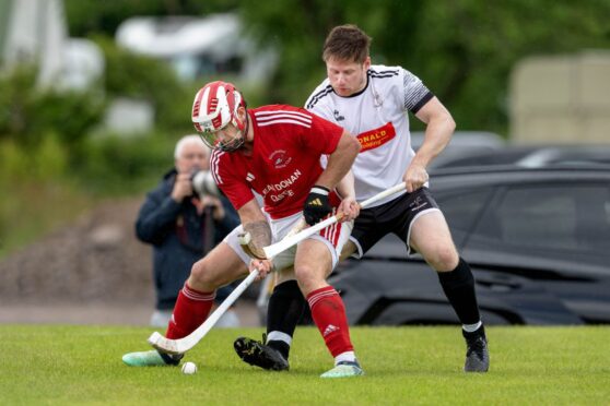 Kinlochshiel's John MacRae in front of Drew Howie, right, of Lovat. Image: Neil G Paterson.