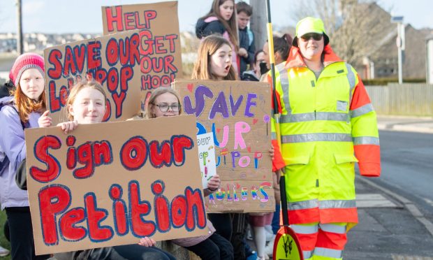 A peaceful protest was held at Portlethen Primary in March over the cuts, pupils are pictured with Lollipop Lady Pamela Gartshore. Image: Kami Thomson/DC Thomson
