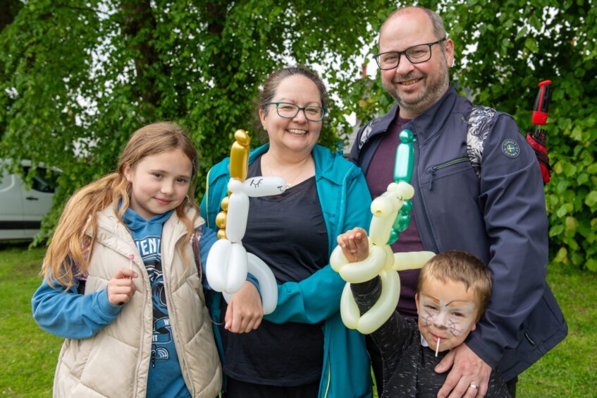 Family of four holding balloons 