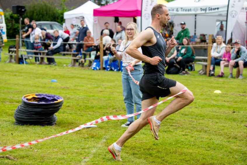 The 90m sprint winner Alan Hamilton crosses the line.