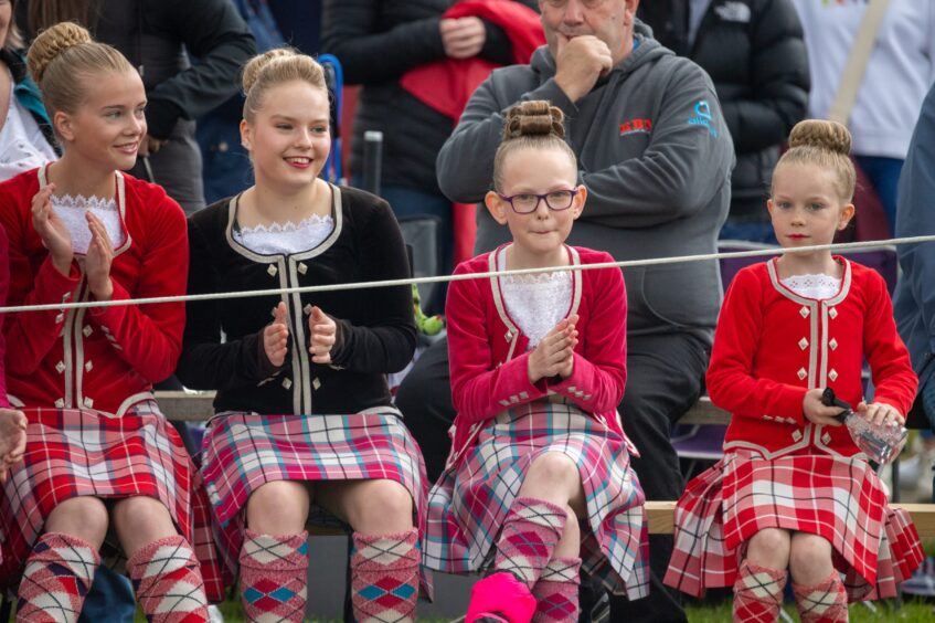 The Highland dancers sit and wait for the competition to begin.