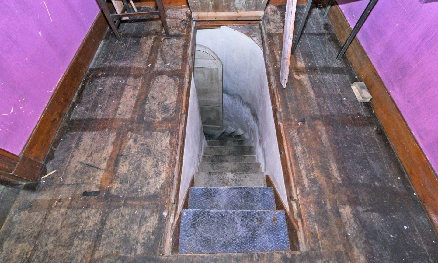 Narrow stairway down to crypt beneath the floor.