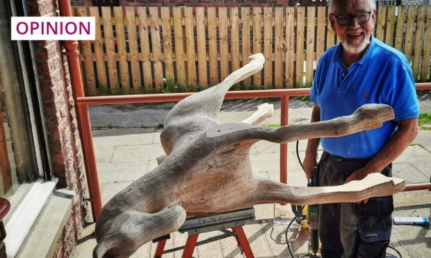 A member of Westhill Men's Shed working on constructing his second wooden rocking horse for his grandchildren