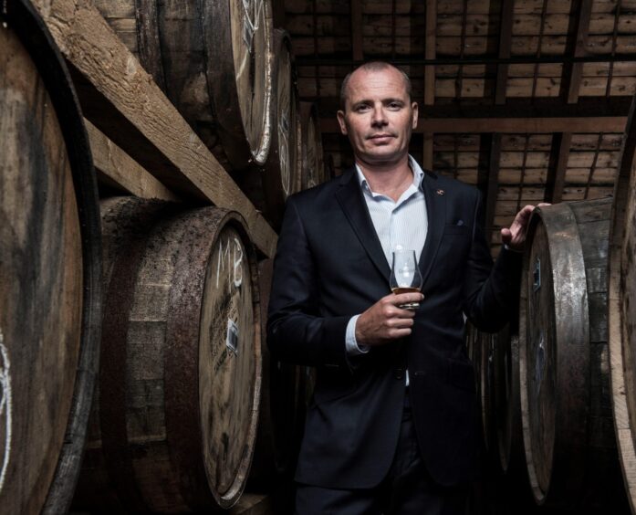 Mitch Betchard, surrounded by whisky casks.