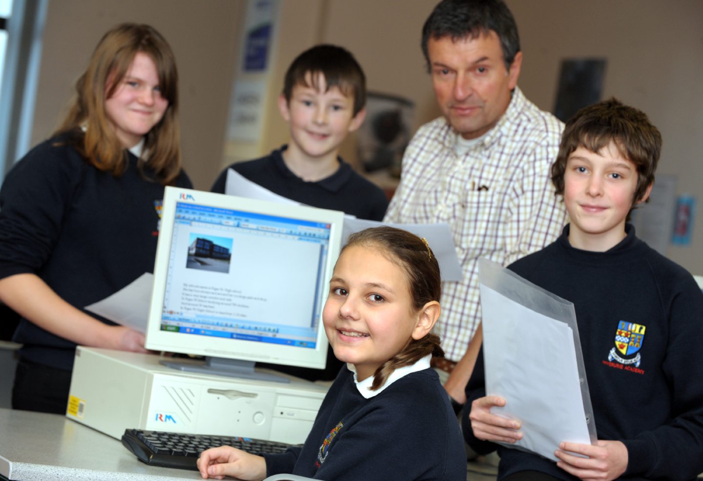 Pupils and their history teacher with a computer