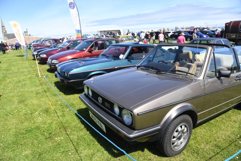 A 1985 VW GOLF GTI ON DISPLAY WITH SEVERAL OTHER HOT HATCHES.
