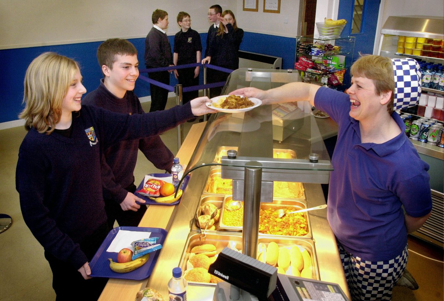 Pupils being handed a plate of food by the dinner lady