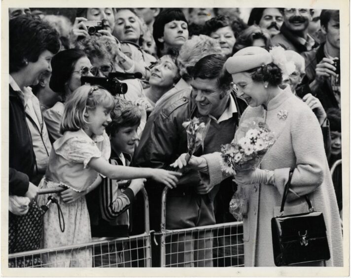 Evelyn and Tony Horsfall and their children, Alistair (8) and Debbie (6) giving a posy to Queen Elizabeth.