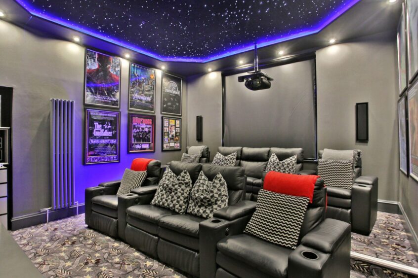 Cinema room at the Aberdeen property features split-level seating with projector and screen.