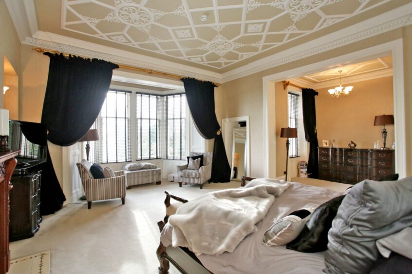 One of the bedrooms at 60 Rubislaw Den South, featuring large bay windows and ornate plasterwork.