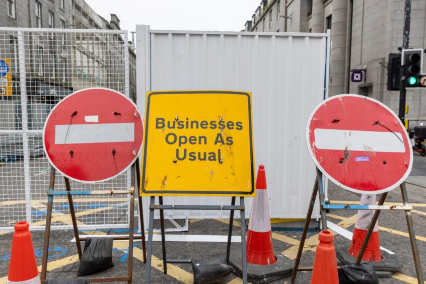 "Businesses open as usual" sign on Union Street amid road closures due to regeneration work.