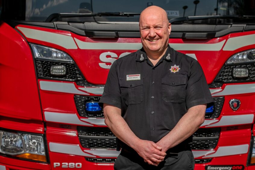 Ross Haggart standing in front of fire engine.