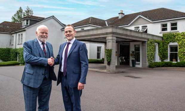 Sir Jim Milne shakes hands on the deal with Marcliffe managing director Ross Spence.