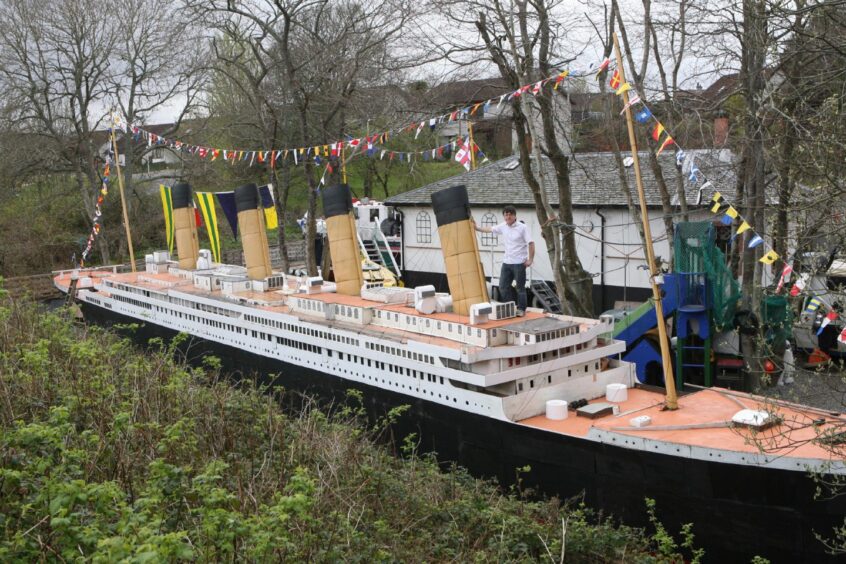 A wide view of the Titanic replica with Stan standing by one of the funnels.