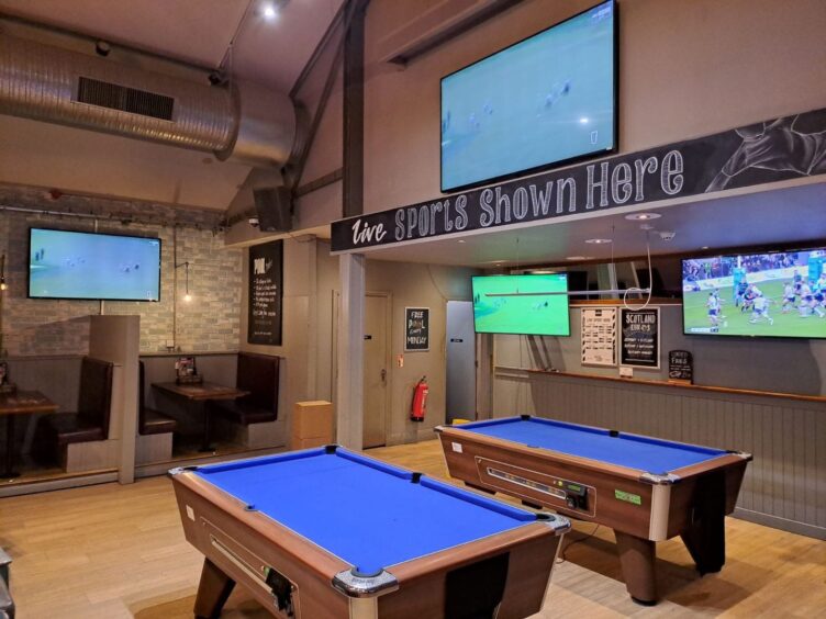 View of pool tables and TV screen at the Inverness pub.