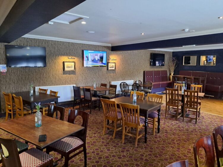 Interior of the Inverness pub featuring a number of TV screens.