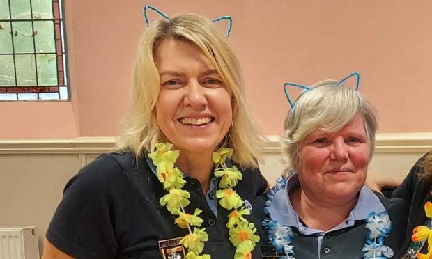 Nicola Youngson (left) pictured with fellow leader Janet Mitchell wearing cat ears and blue and yellow garlands.