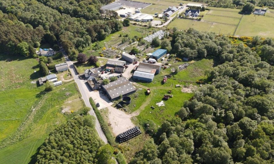 Aerial view of the Peterculter site featuring a main farmhouse and various sheds.