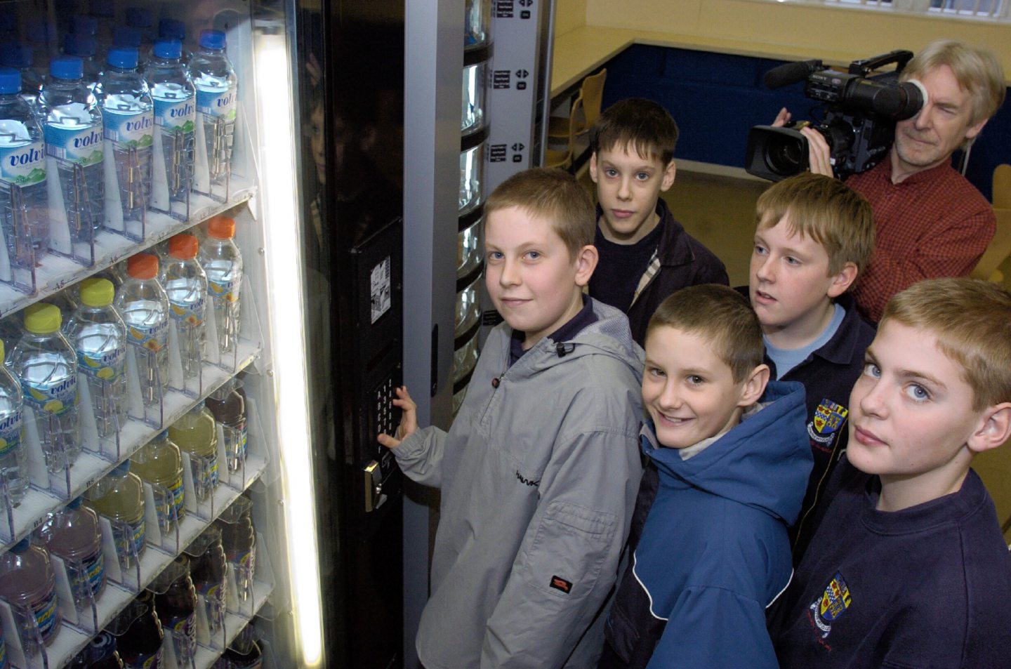 Pupils with a cameraman gathered around a vending machine