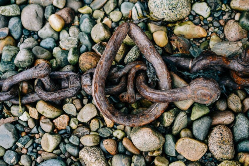 Rusty chains on the beach where the Old Boat of Coal rests. Image: Shutterstock.