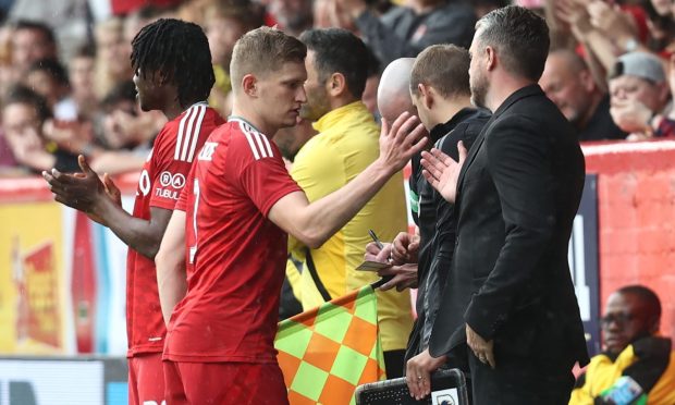 Aberdeen full-back Jack MacKenzie is substituted off and shakes hands with Aberdeen manager Jimmy Thelin during the 6-0 win over Dumbarton. Image: Shutterstock.