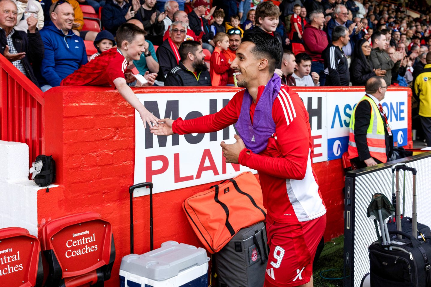 Aberdeen's Bojan Miovski shakes the hand of a young fan before a Premier Sports Cup group stage match against Airdrie at Pittodrie. Image: SNS 