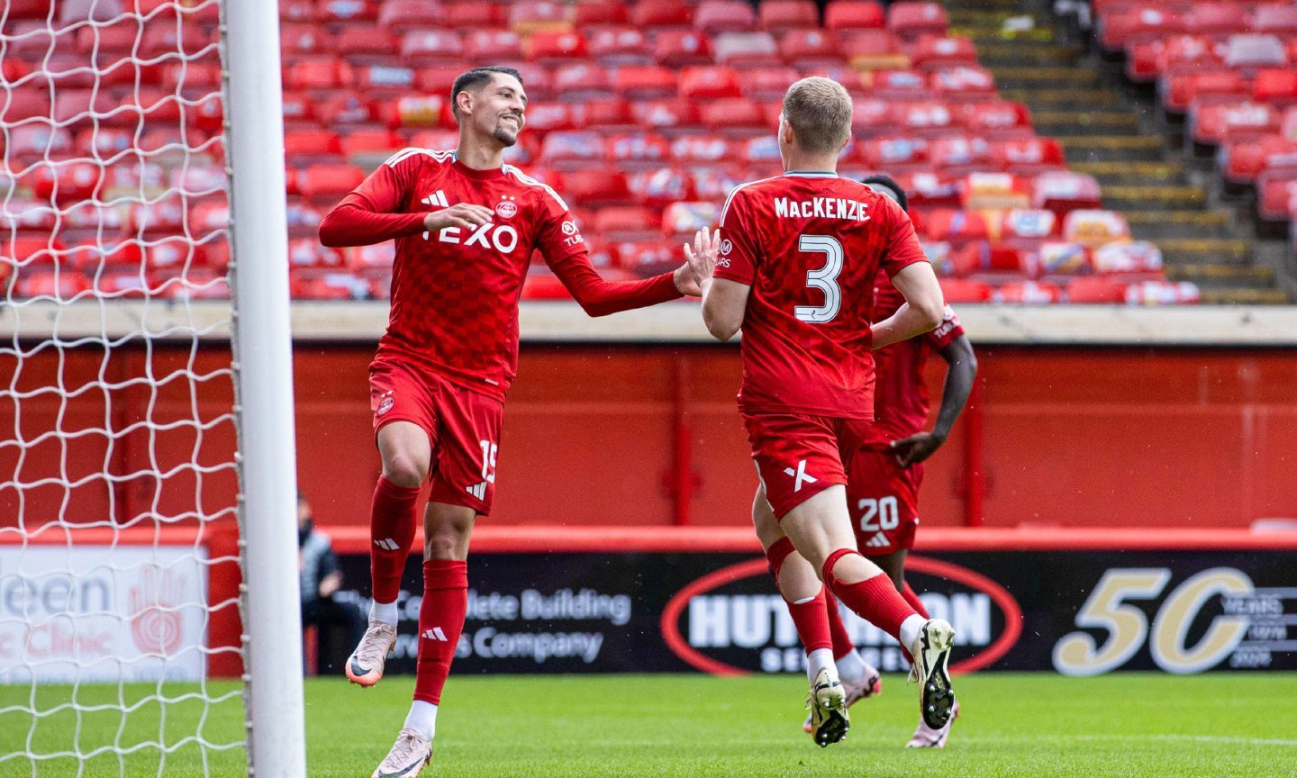 Aberdeen's Jack MacKenzie celebrates with Ester Sokler as he scores to make it 1-0 against Dumbarton at Pittodrie. Image: SNS