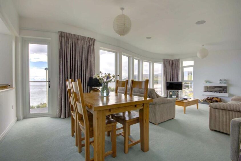 The sitting/dining room at the Old Couastguard Station, with access to a balcony with views out to the sea. 