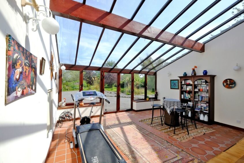 A room in the county home near Aberdeen with lots of natural light, a small table and chair set and a treadmill