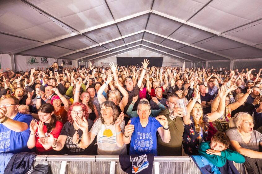 Crowds dance with their arms in the air at Speyfest.