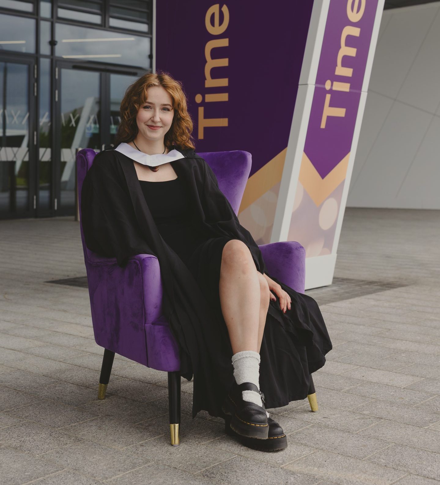 Shetland RGU graduate on a purple armchair outside the campus