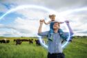 dad smiles at girl sitting on his shoulders while walking to Turriff show for food and drink