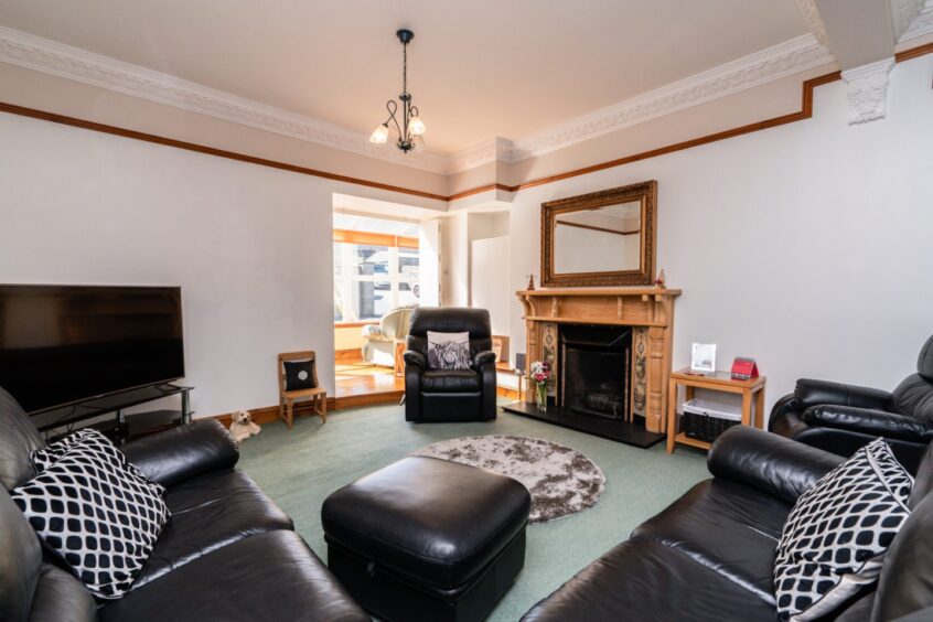 Living area at the house for sale in Longside, featuring an open fire and wood-burning stove.