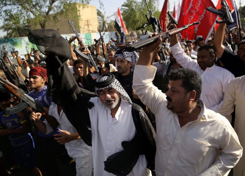 Shiite tribal fighters raise their weapons and chant slogans in Basra, Iraq's second-largest city, 340 miles south-east of Baghdad, in June 2014.