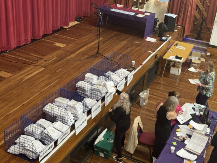 The piles of ballots. Graham and Kathleen have high piles and the vote looks close.