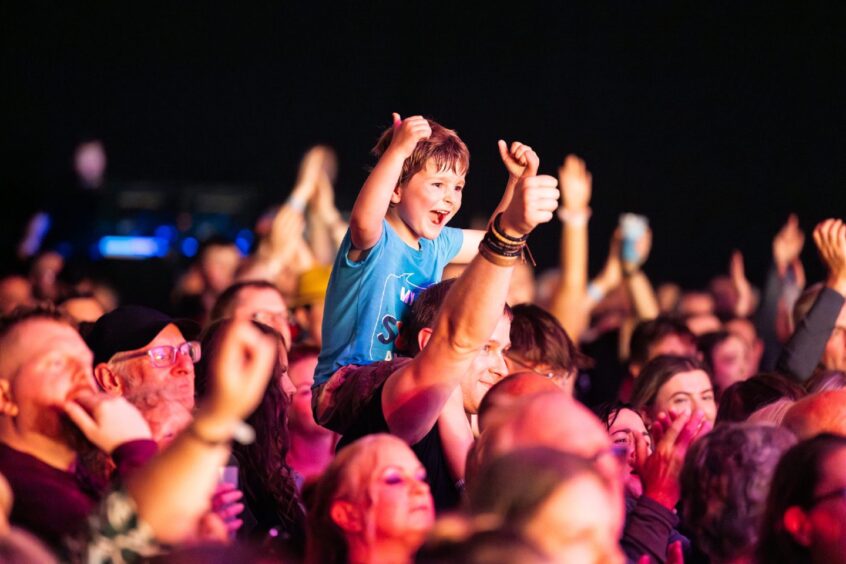 Crowds waving their hands in the air.