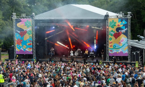 a crowd stands before a stage at Belladrum