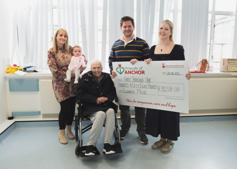 Liz Milne with her family and the cheque for Friends of Anchor