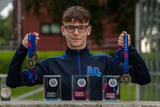 Aiden Anderson, with his medals from his three open water swimming races.
Image: Kenny Elrick/DC Thomson