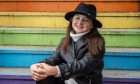 Erin Inglis smiling into the camera on the rainbow stairs at Castlegate in Aberdeen