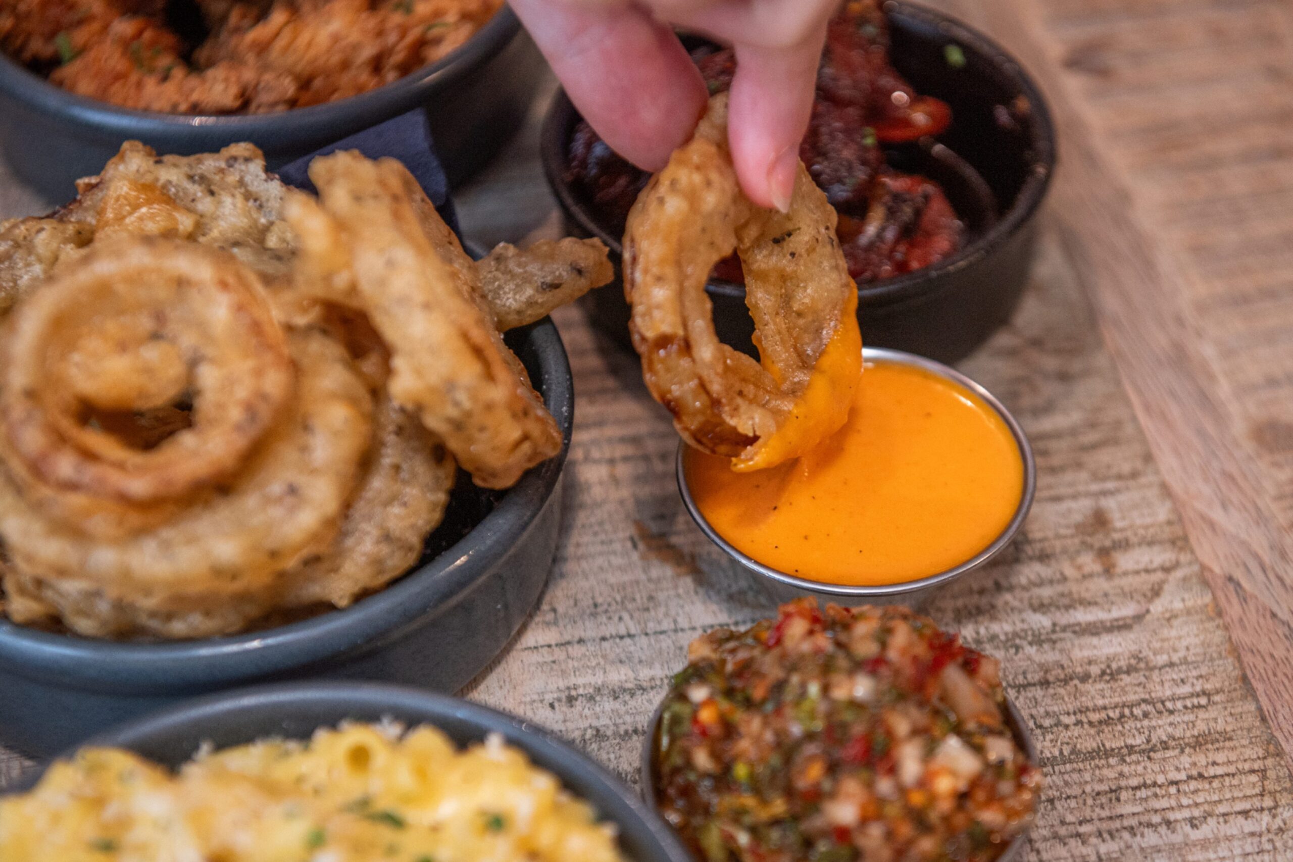 Dipping an onion ring into the buffalo sauce.