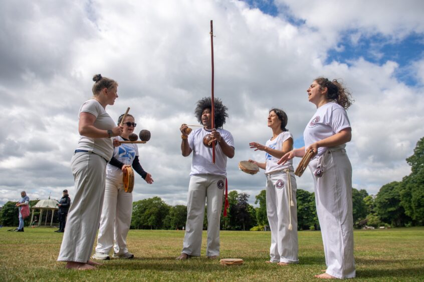 Students singing and playing music at the end of a capoeira class in Aberdeen.