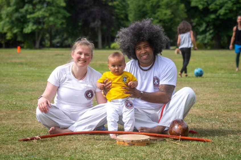 Capoeira instructors Julia Wouters and Mestre Baiano, with their son Hugo in Duthie Park, Aberdeen.