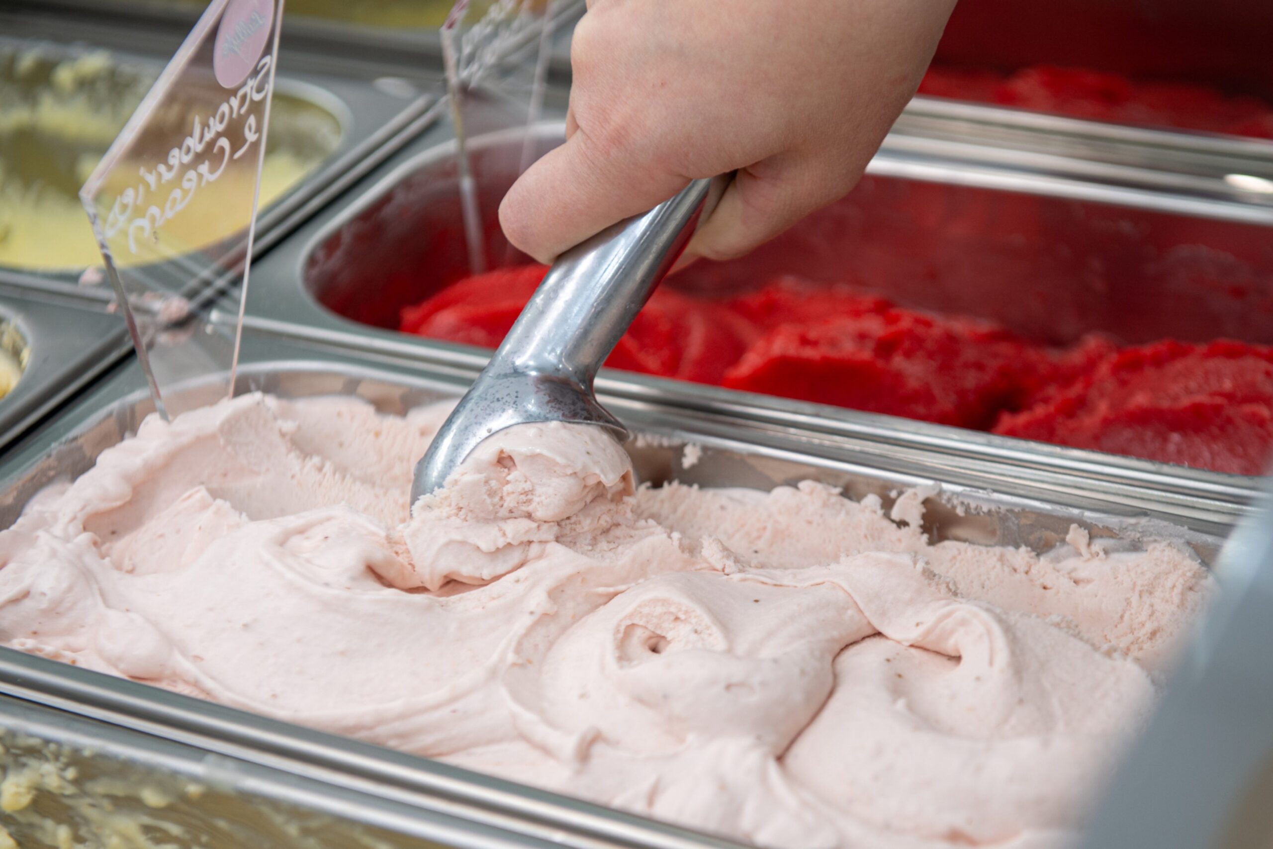 Strawberry and cream ice cream being scooped