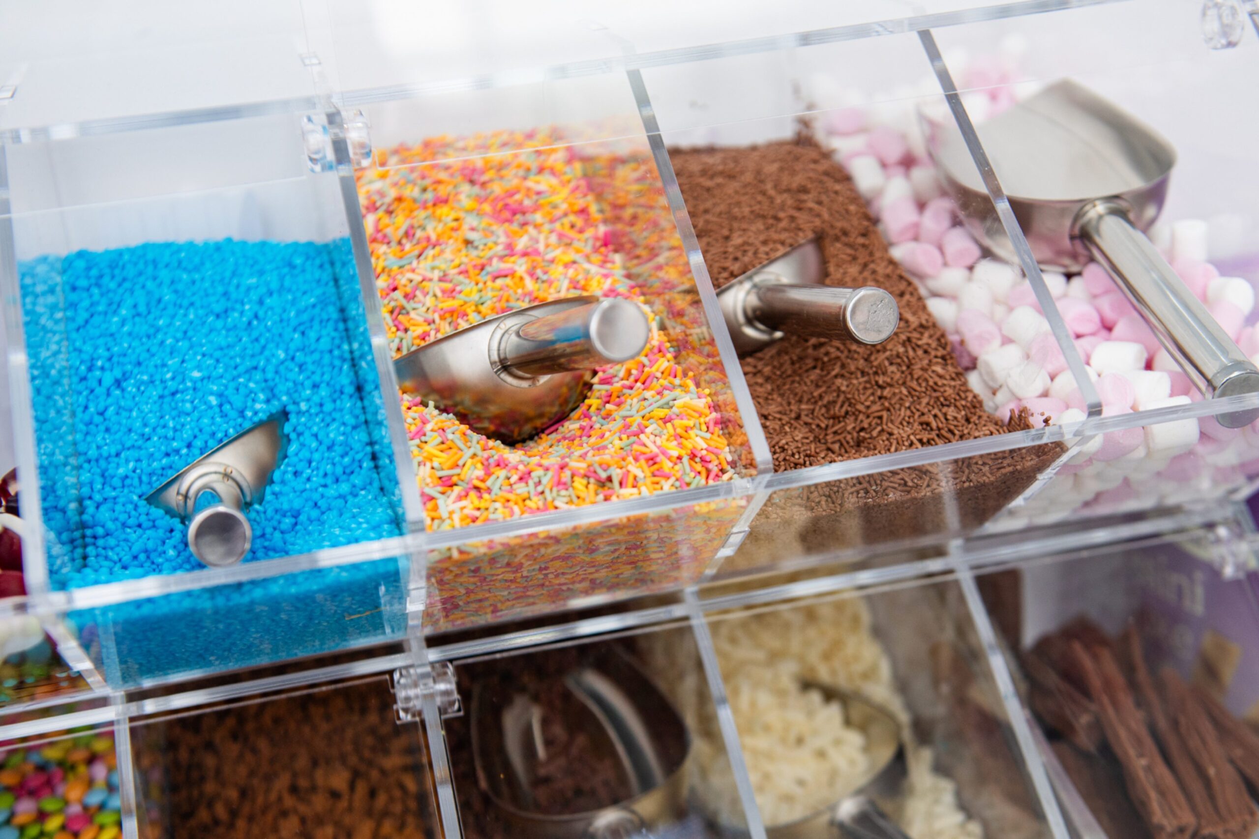 A selection of ice cream toppings including marshmallows and sprinkles