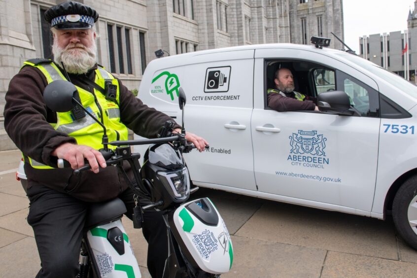 City warden Philip Milne on his new council steed, alongside Scott Thomson in one of Aberdeen's new ANPR parking camera vans. Image: Kami Thomson/DC Thomson