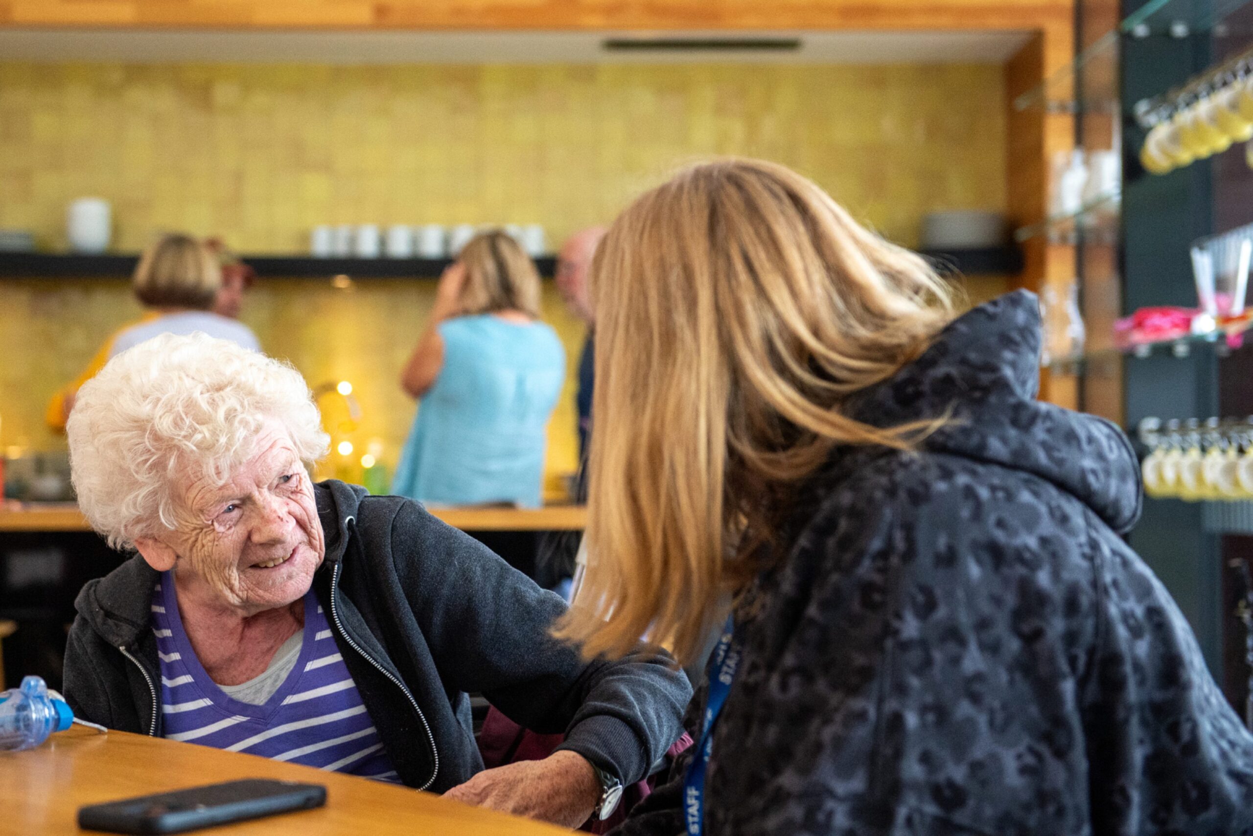 Pensioner Diane Skinner leans forward smiling as she talks about Maggie's Aberdeen and cancer to Lindsay Bruce.