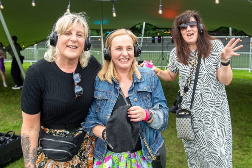 Three women wearing headphones at silent disco