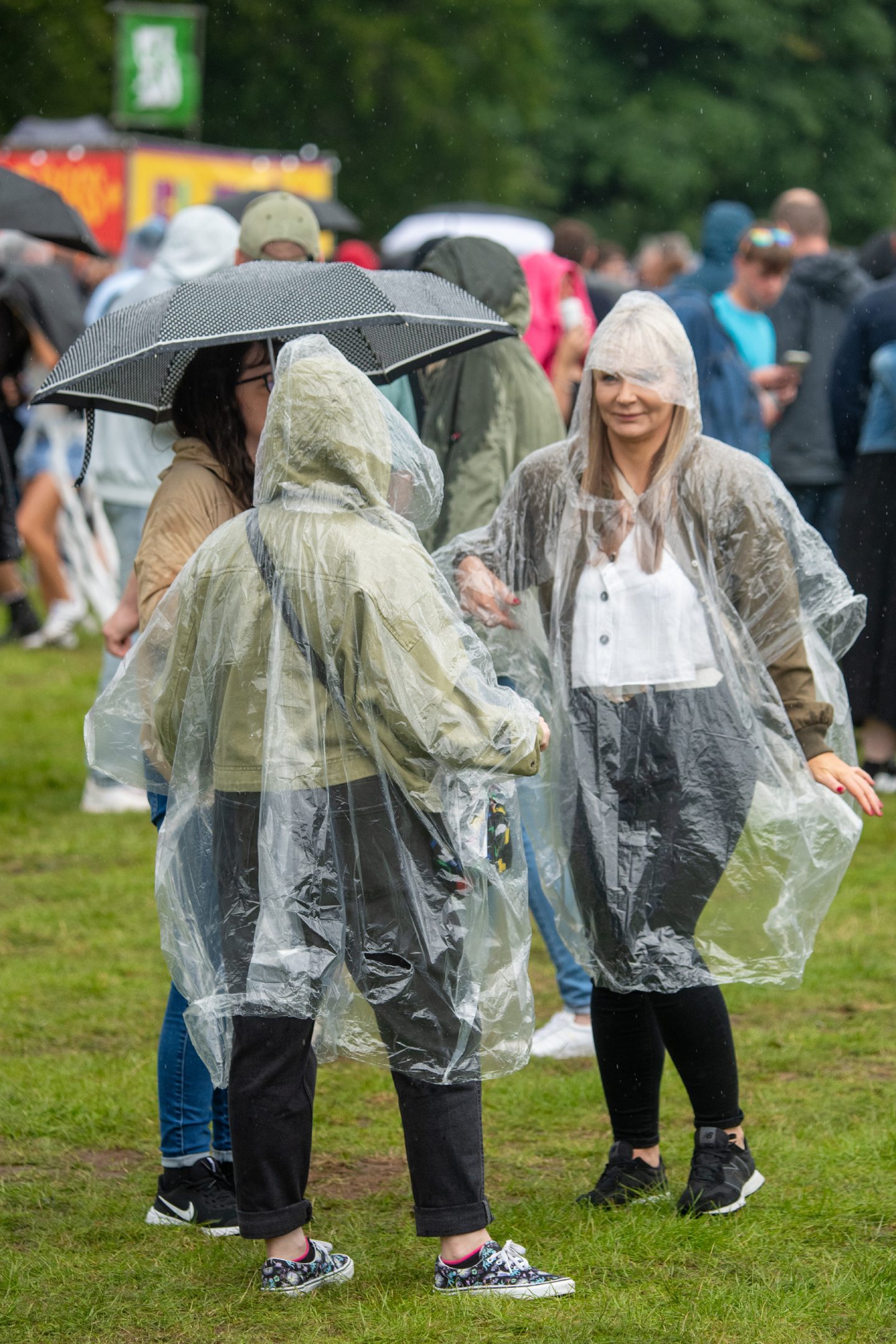 Women dancing in rain wearing clear plastic ponchos 